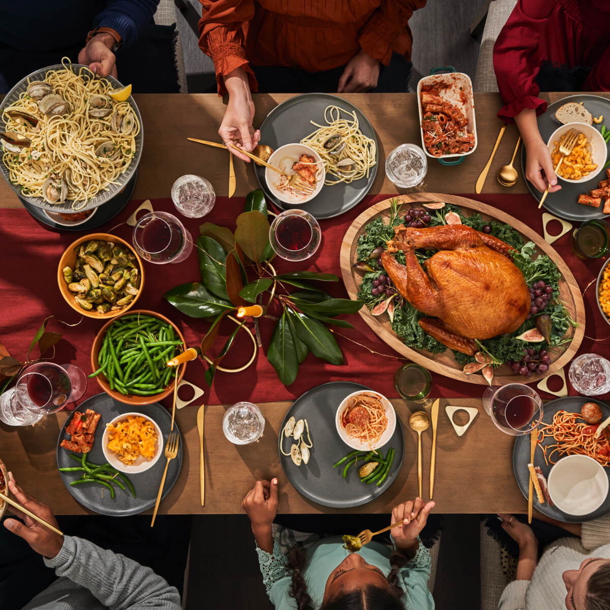 Holiday Tablescape Setting With Family Serving Pasta And Other Dishes