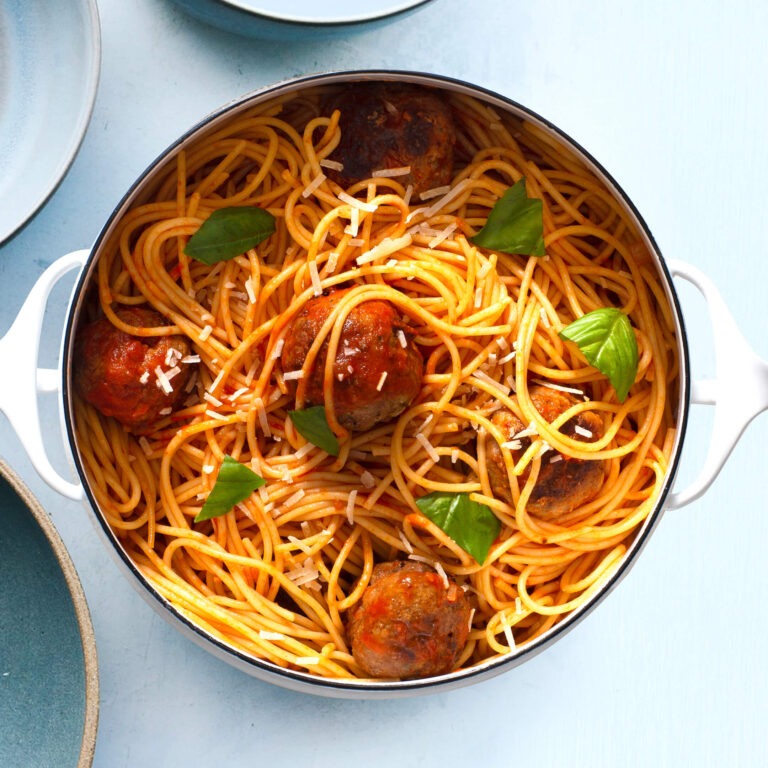 Pot of spaghetti pasta in tomato sauce with meatballs and basil