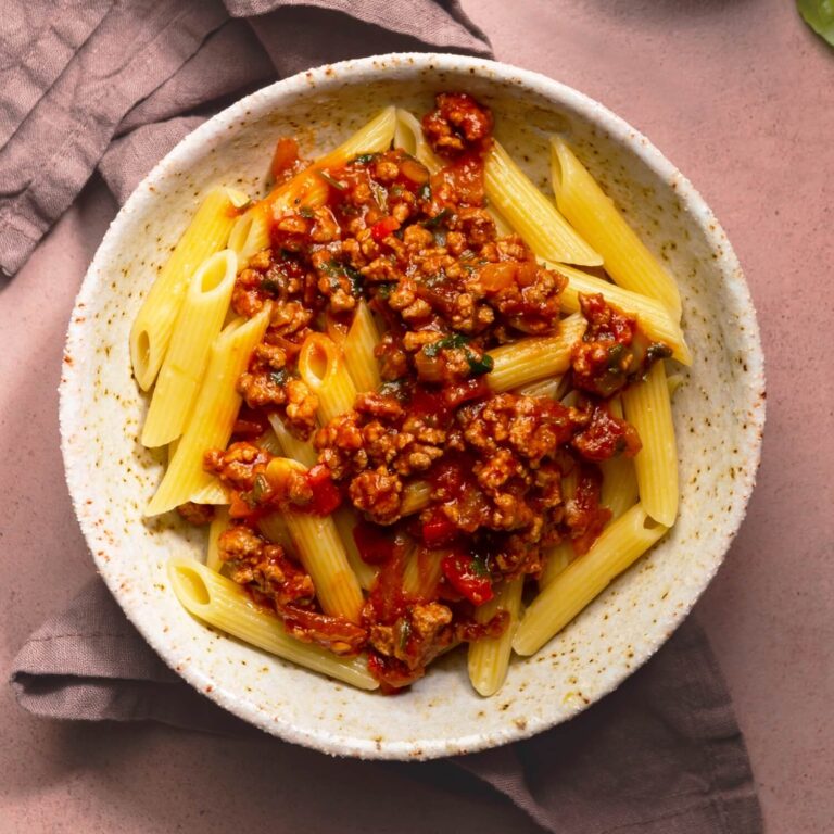 penne rigate with meat sauce in serving bowl