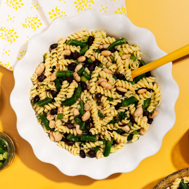 Rotini with beans in a citrus sauce in a serving bowl