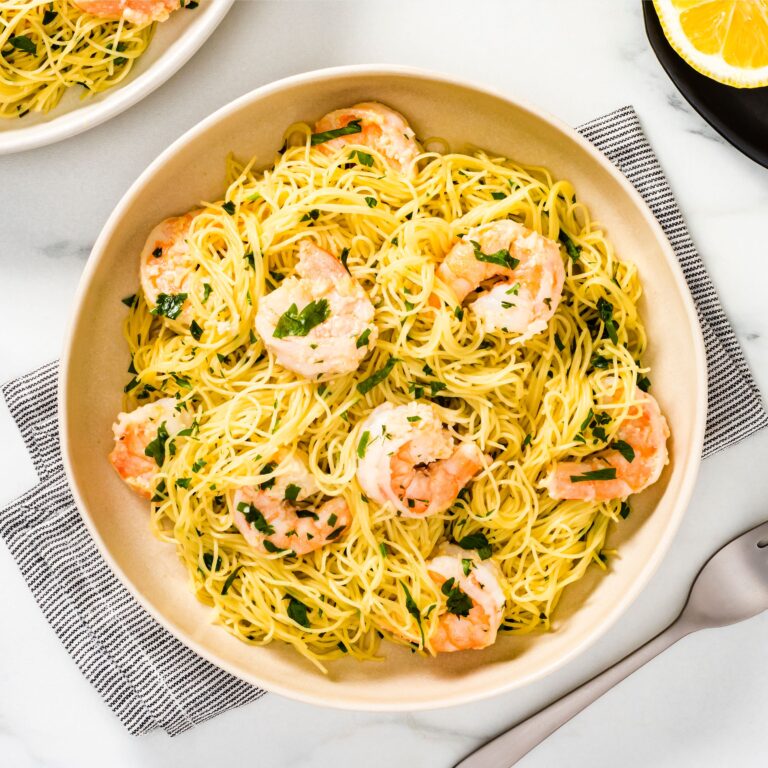 Thin pasta shrimp scampi with herbs in bowl with lemon
