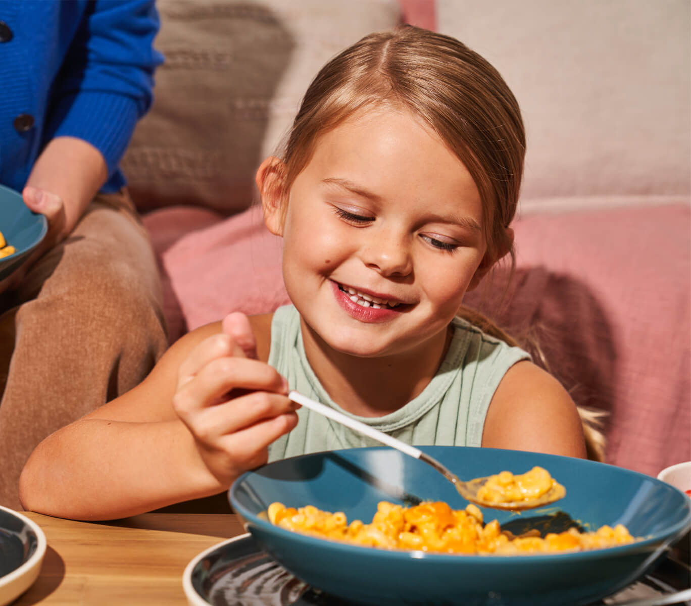 Smiling Girl With Spoonful Of Mac And Cheese Pasta