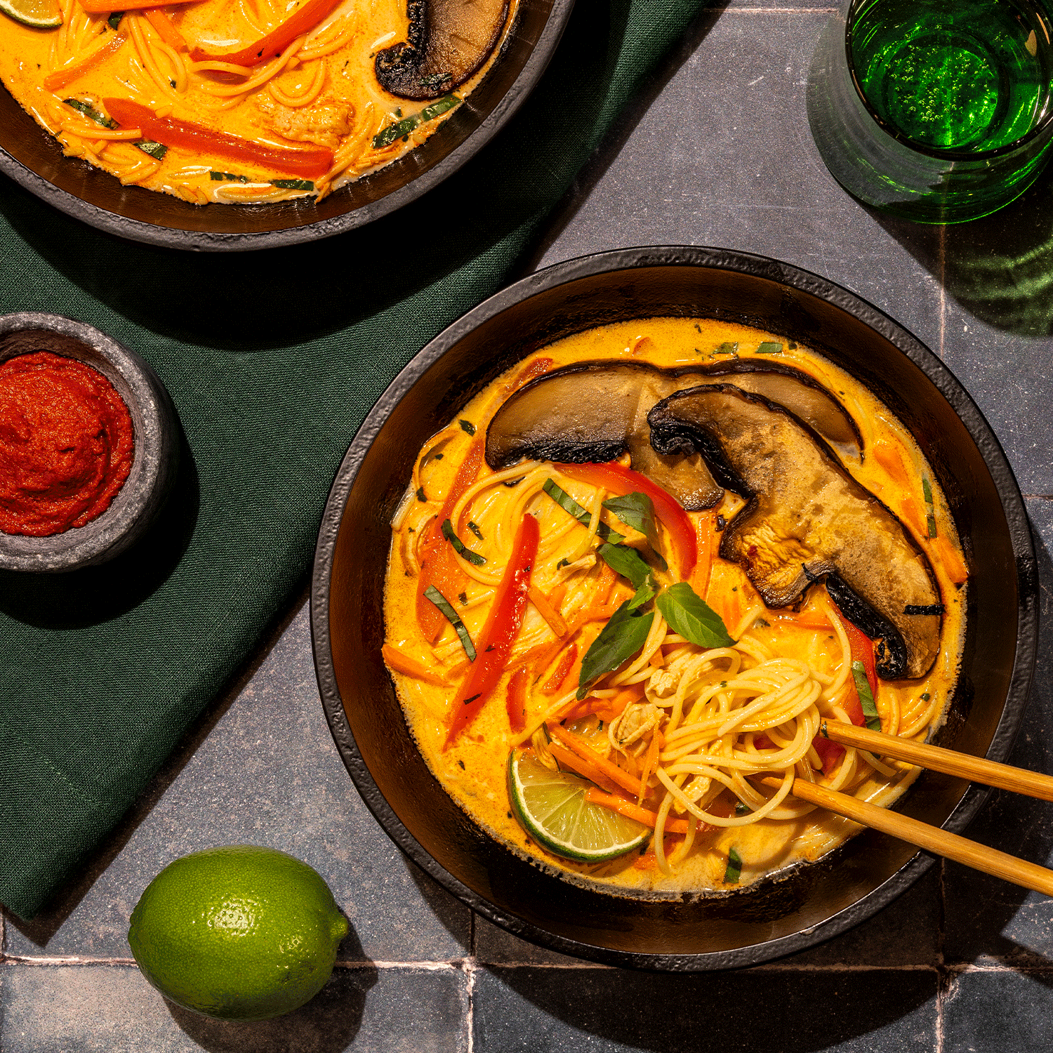 bowl of noodles, mushroom, green peppers in curry broth