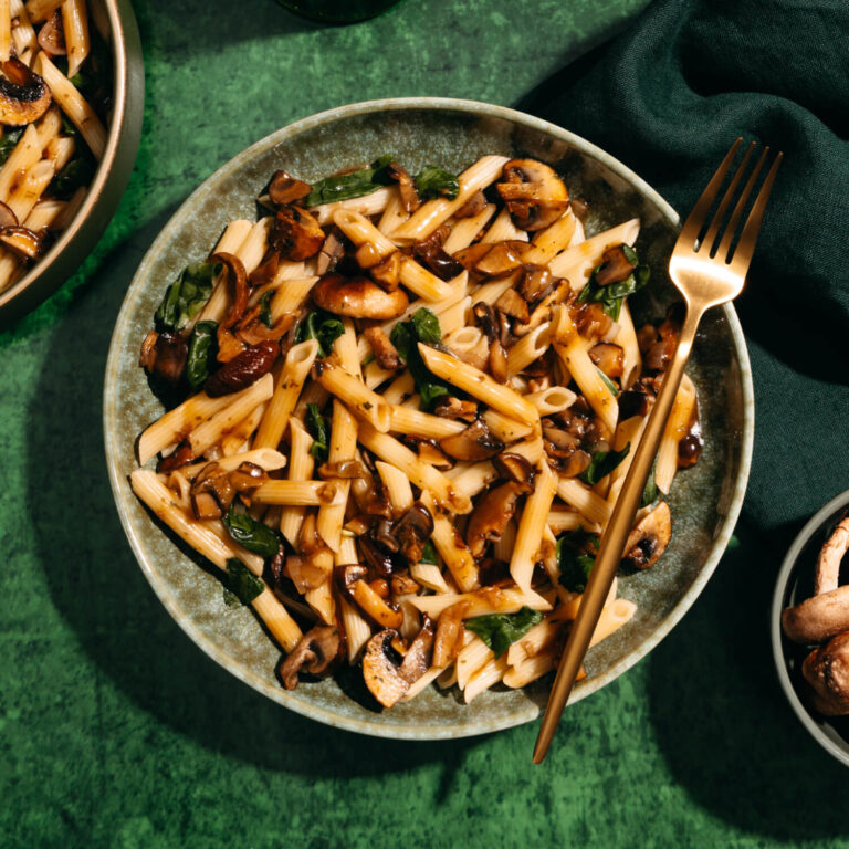 Two bowls of Wild Mushroom Penne, a mushroom and spinach pasta made with Ronzoni® Penne Rigate.
